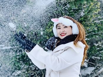 Portrait of young woman standing in snow