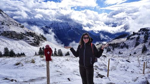 Full length of woman standing on snowcapped mountain