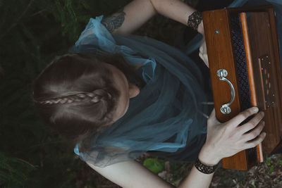 Female druid unlocking wooden secret box scenic photography