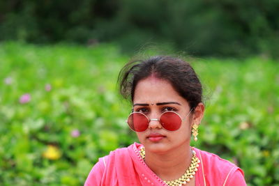 Portrait of young woman wearing sunglasses sitting outdoors