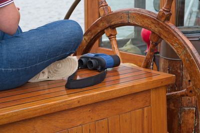 Low section of person sitting on wooden table