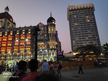 People on illuminated buildings in city