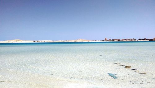 Scenic view of beach against clear blue sky