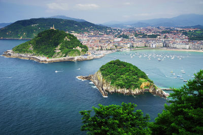 High angle view of city by sea against sky