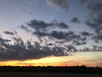 Scenic view of silhouette field against sky during sunset