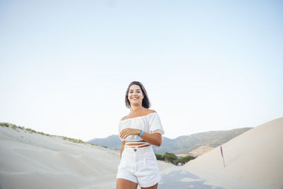 Young woman walking along the dunes