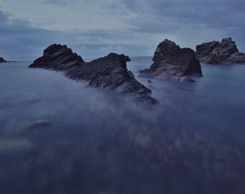 Rocks in sea against sky