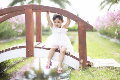 Rear view of young woman standing by railing