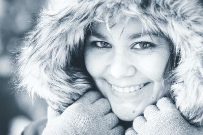 Close-up portrait of smiling young woman in snow