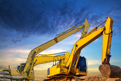 Low angle view of crane against sky during sunset