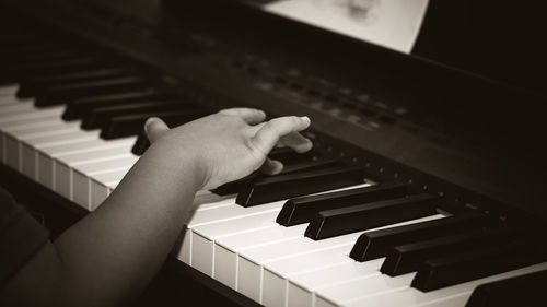 Cropped image of person playing piano