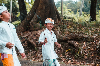 Young man and woman standing on land in forest