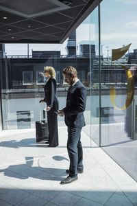 Side view of business people standing in hotel corridor