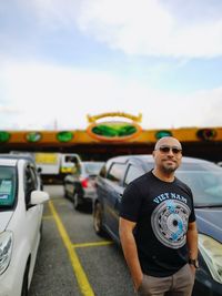 Portrait of man standing in car