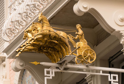 Low angle view of sculpture on staircase of building
