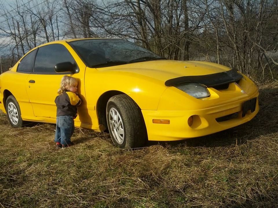 mode of transportation, yellow, transportation, car, land vehicle, motor vehicle, tree, plant, day, real people, full length, nature, one person, stationary, childhood, standing, outdoors, field, men