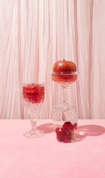 Still life arrangement of cristal glasses filled with red apples and celosia flower. copy space