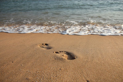 High angle view of footprints on sand at beach