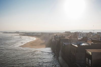 High angle view of buildings by sea against clear sky