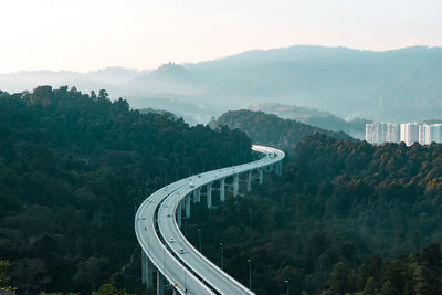 High angle view of road amidst trees against sky