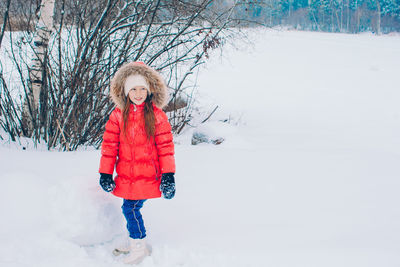 Portrait of woman standing on snow covered field