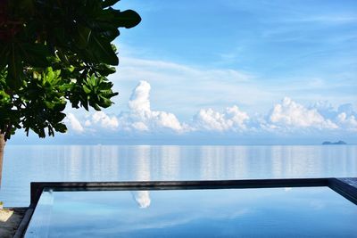 Swimming pool by sea against sky