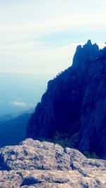 Scenic view of mountain by sea against sky