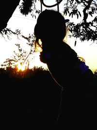 Silhouette girl and tree against sky during sunset