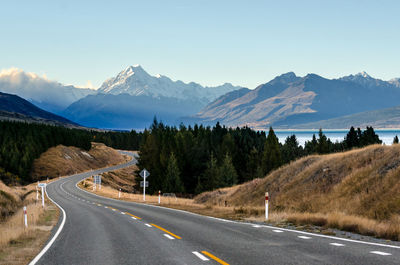 Road by mountains against sky