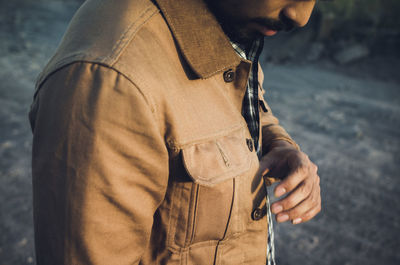 Midsection of man holding smart phone