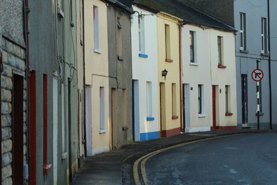 Empty road by buildings in city