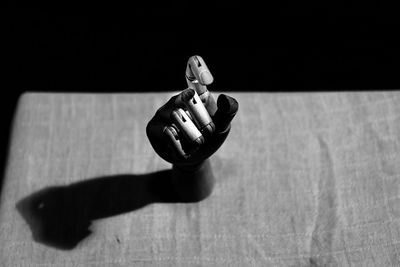 Close-up of robot hand on tablecloth against black background