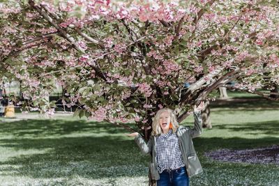 Portrait of girl standing by cherry tree