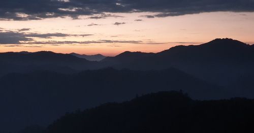 Scenic view of silhouette mountains against sky at sunset
