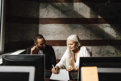 Female financial advisor discussing over contract with businessman at office