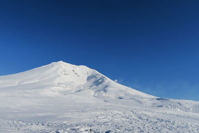 Scenic view of snowcapped mountains against clear blue sky