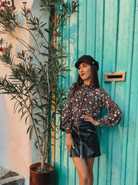 Young woman looking away while standing against plants