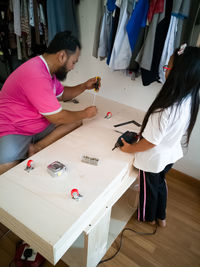 Man with girl repairing table