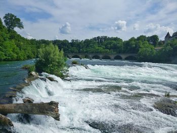 Scenic view of waterfall against sky