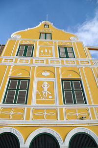 Low angle view of yellow building against sky