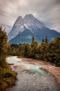 Scenic view of lake by mountains against sky