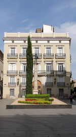 Residential buildings by street against sky