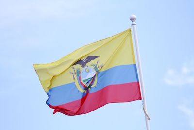 Low angle view of flag against blue sky