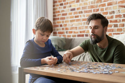 Boy playing with toy blocks at home