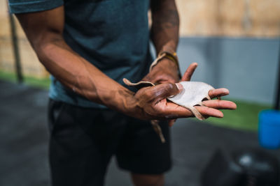 Midsection of man holding textile while standing in gym