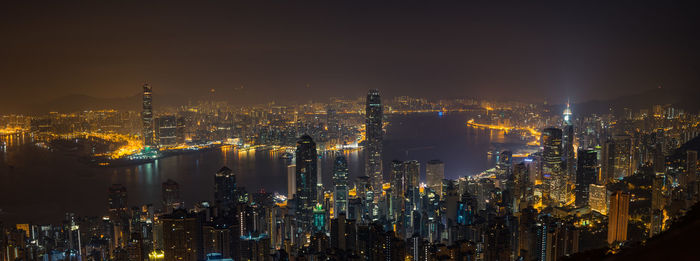 Illuminated cityscape against sky at night