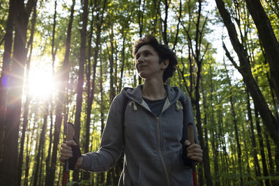 Nordic walking. beautiful happy caucasian woman training in park, forest with sticks. physical