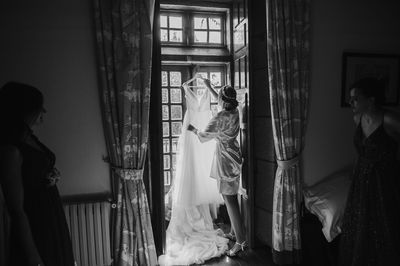 Woman standing by window at home