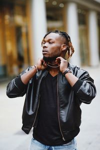 Young man looking away in city