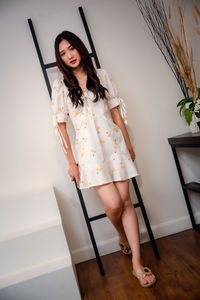 Young woman standing against wall